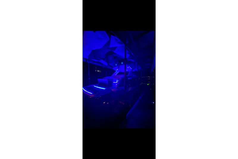 Slide: The Image of 2021 Formula 350 Crossover Bowrider I/O illuminated with blue LED lights at night. - 3