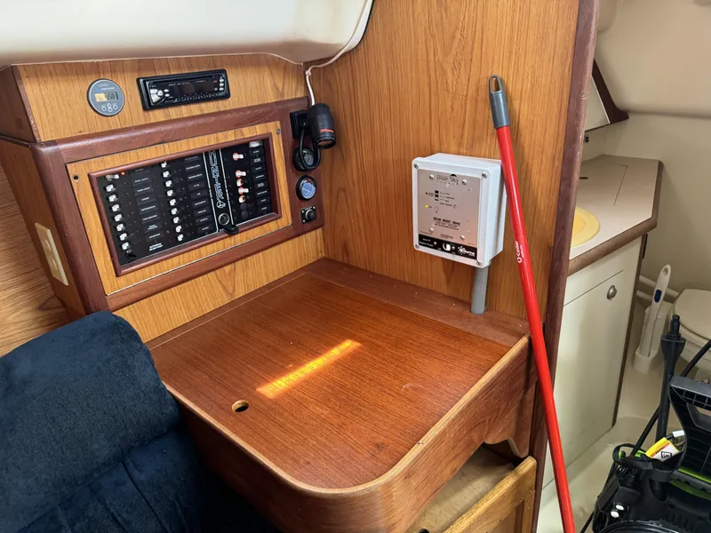 Slide: The Image of Interior of a 2000 Hunter 290 sailboat with wooden table and control panel. - 24