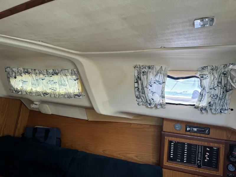 Slide: The Image of Interior of a 2000 Hunter 290 yacht with curtains and control panel. - 29