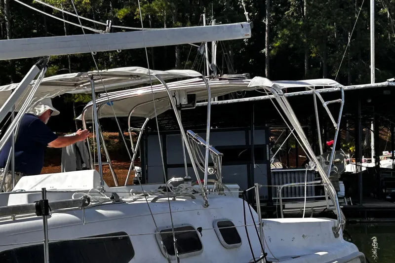 Slide: The Image of Man on a 2000 Hunter 290 sailboat at a marina, surrounded by trees. - 5