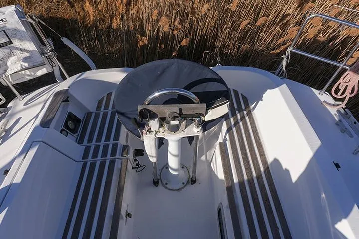 Slide: The Image of Cockpit of 1991 Beneteau First 310 sailboat with steering wheel and seating. - 12