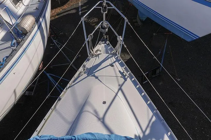Slide: The Image of Bow view of a 1991 Beneteau First 310 sailboat, docked with rigging visible. - 19