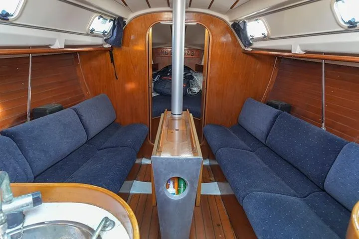 Slide: The Image of Interior of 1991 Beneteau First 310 sailboat with blue seating and wooden finishes. - 22