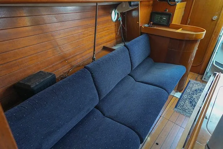 Slide: The Image of Interior of 1991 Beneteau First 310 sailboat with blue sofa and wooden paneling. - 24