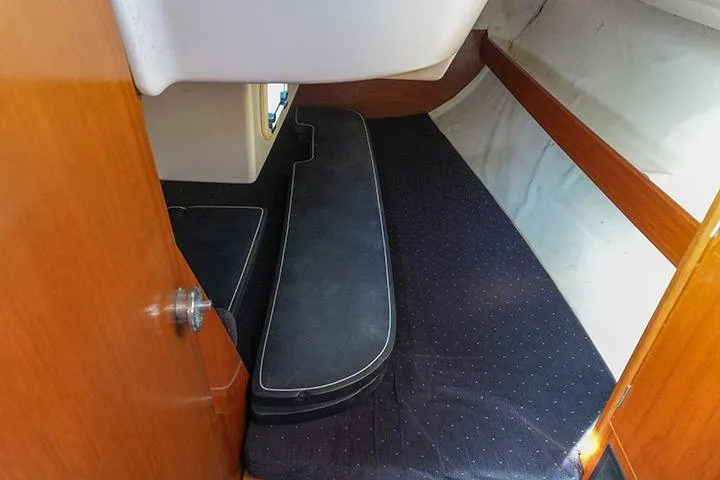 Slide: The Image of Interior cabin of 1991 Beneteau First 310 sailboat, featuring wooden finishes and cushioned seating. - 30