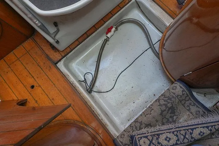 Slide: The Image of Interior view of a 1991 Beneteau First 310 sailboat, featuring a floor compartment with a hose. - 38