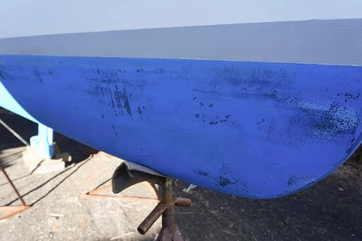 Slide: The Image of Close-up of a 1991 Beneteau First 310 sailboat hull with blue paint. - 6