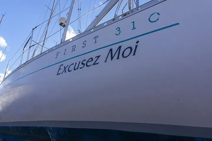Slide: The Image of 1991 Beneteau First 310 sailboat named "Excusez Moi" docked under blue sky. - 8
