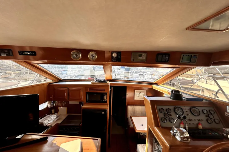 Slide: The Image of 1989 Ocean Alexander 44 CPMY yacht interior with helm, gauges, and kitchen area. - 15