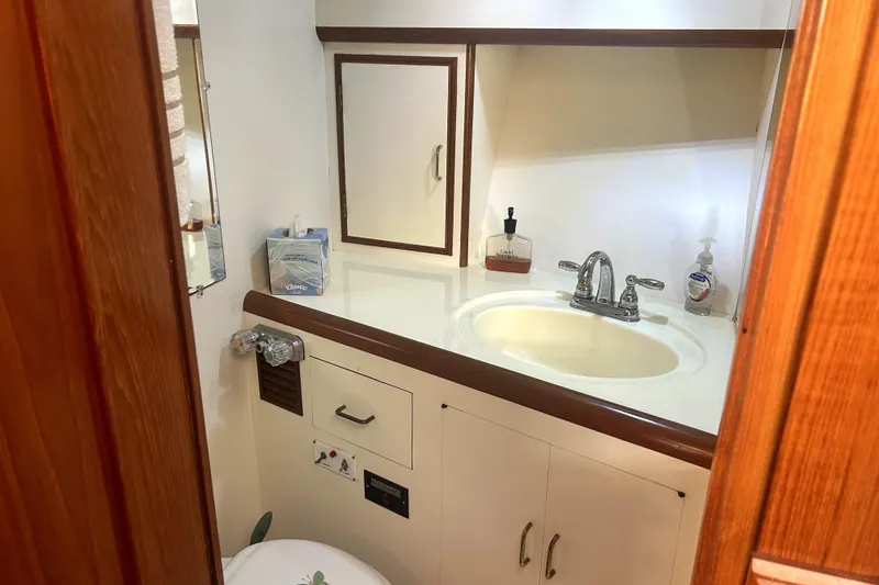Slide: The Image of 1989 Ocean Alexander 44 CPMY yacht bathroom with sink, mirror, and wooden cabinetry. - 22