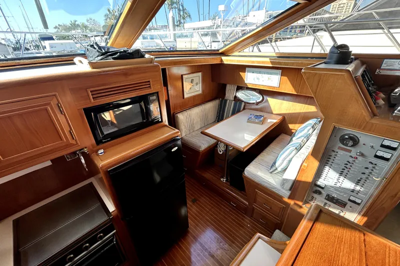 Slide: The Image of 1989 Ocean Alexander 44 CPMY yacht interior with wood finish, kitchenette, and seating area. - 24