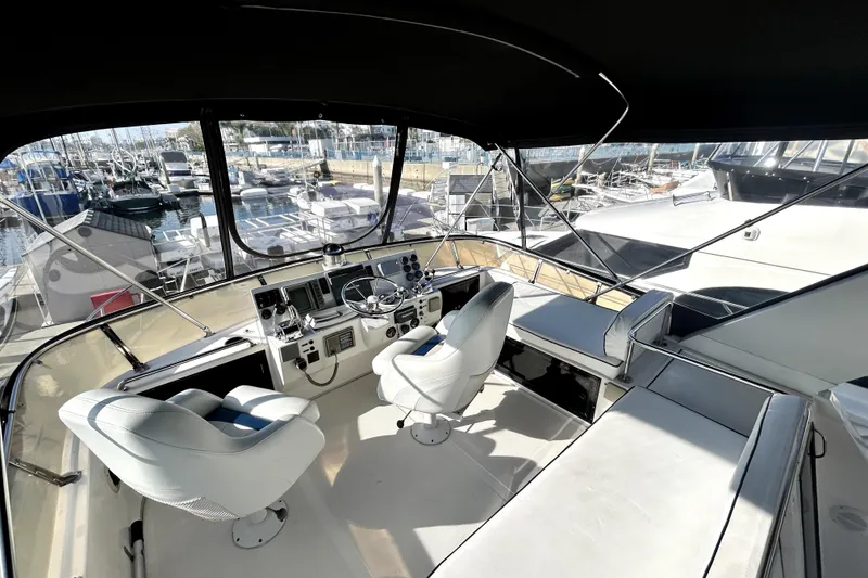 Slide: The Image of 1989 Ocean Alexander 44 CPMY yacht cockpit with helm, seating, and marina view. - 6