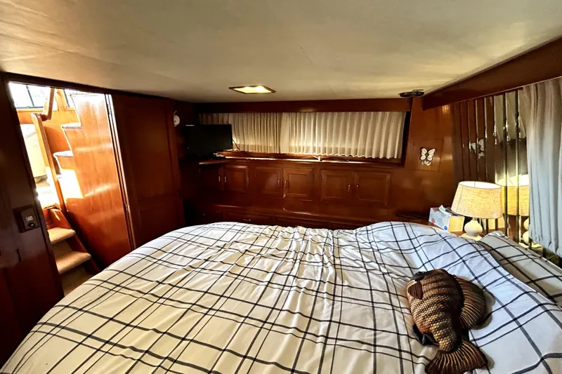 Slide: The Image of 1989 Ocean Alexander 44 CPMY cabin with bed, wooden interior, and natural light. - 18