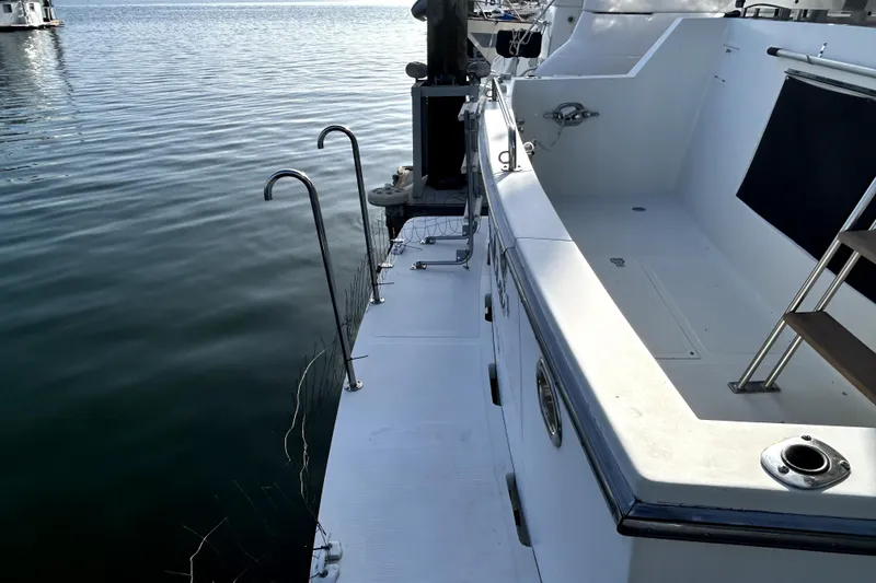 Slide: The Image of 1989 Ocean Alexander 44 CPMY yacht docked, featuring a sleek white deck and stainless steel railings. - 2