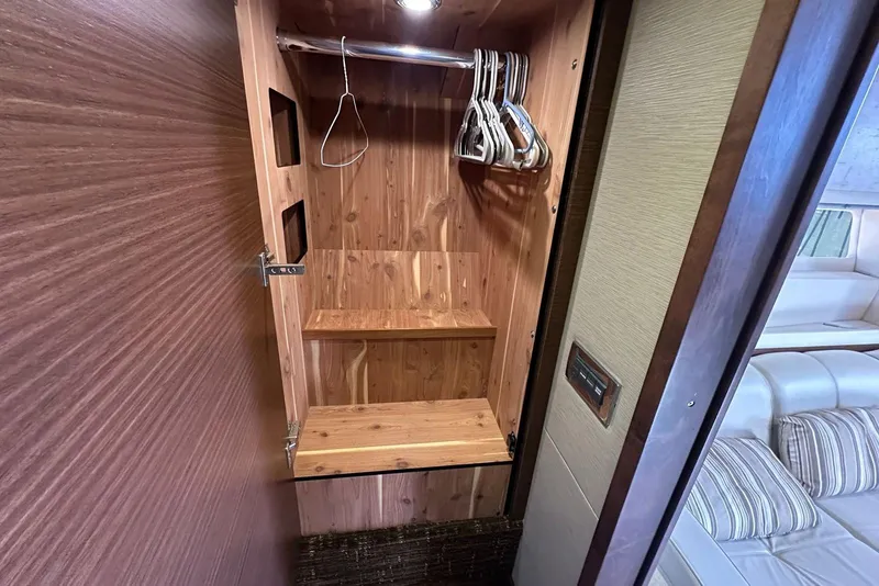 Slide: The Image of 2014 Sea Ray 410 Sundancer wooden closet interior with hangers and shelves. - 40