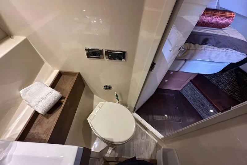 Slide: The Image of 2014 Sea Ray 410 Sundancer bathroom with toilet, towel, and view into cabin. - 43