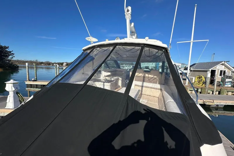 Slide: The Image of 2014 Sea Ray 410 Sundancer yacht docked, featuring covered cockpit and clear blue sky. - 55