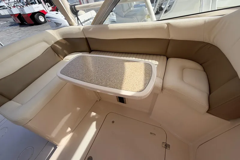 Slide: The Image of 2013 Grady-White Freedom 335 boat interior with cushioned seating and table. - 100