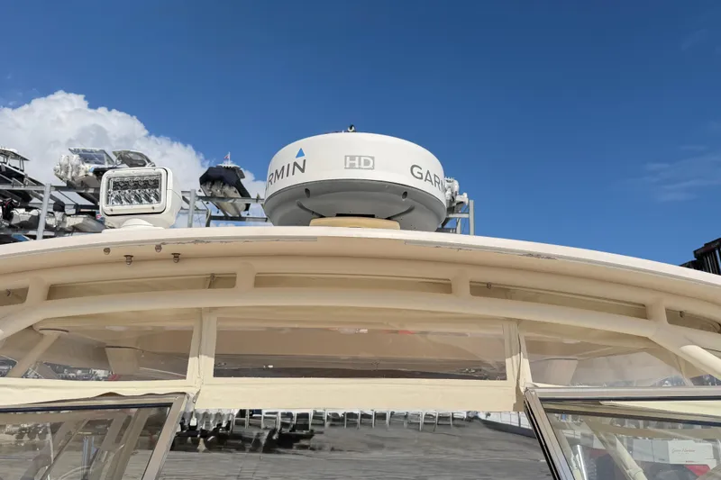 Slide: The Image of 2013 Grady-White Freedom 335 boat with spacious seating, docked in a marina. - 103