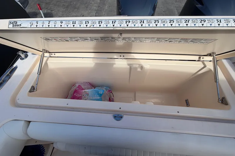 Slide: The Image of 2013 Grady-White Freedom 335 boat interior with sink, storage drawers, and open fridge. - 119