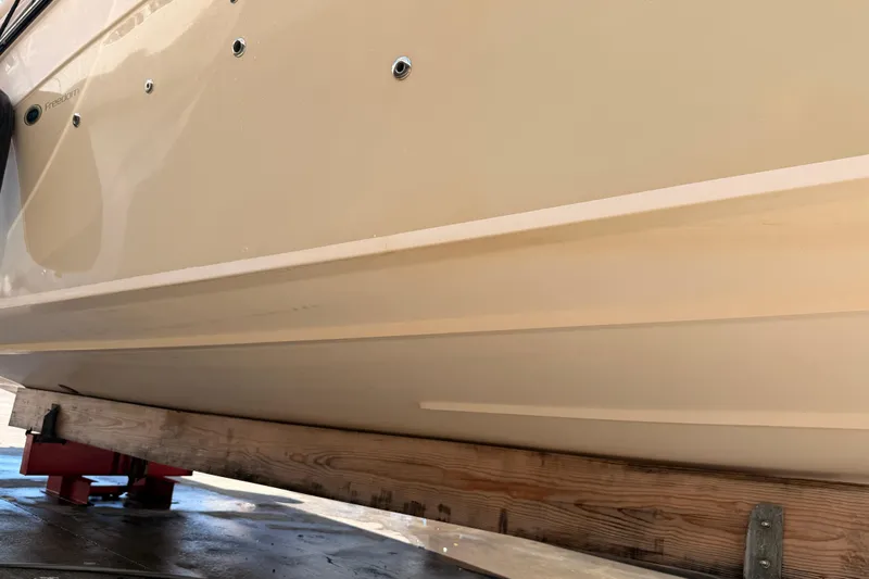 Slide: The Image of 2013 Grady-White Freedom 335 boat hull on wooden support, side view. - 146