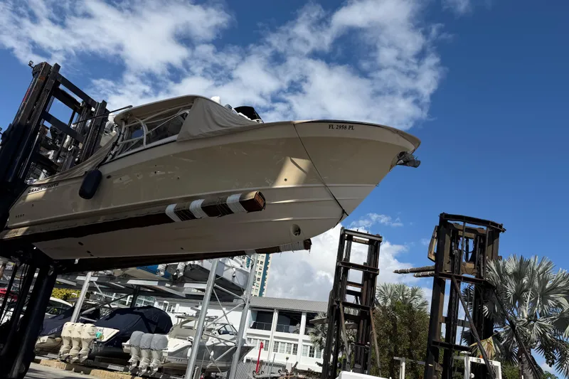 Slide: The Image of 2013 Grady-White Freedom 335 boat lifted by forklift under blue sky. - 148