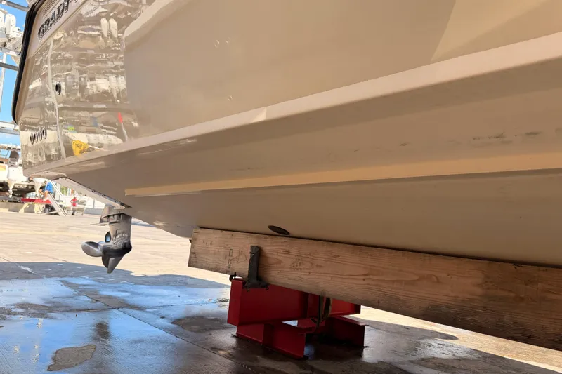 Slide: The Image of 2013 Grady-White Freedom 335 boat on lift, clear sky, palm trees in background. - 150