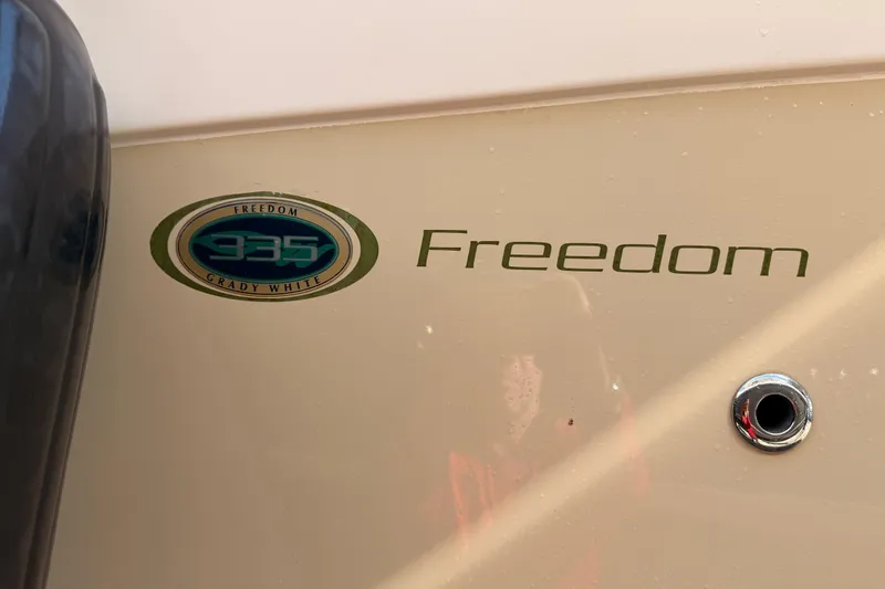 Slide: The Image of 2013 Grady-White Freedom 335 boat covered in tarp, docked among other boats. - 151