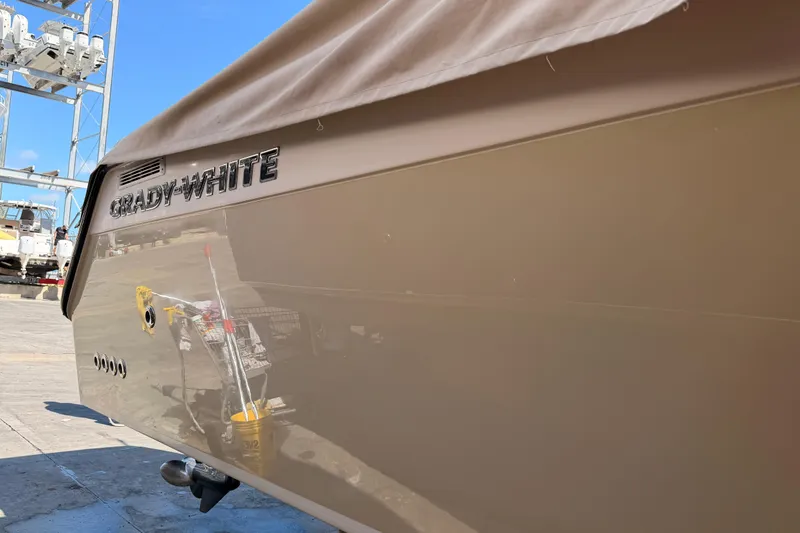 Slide: The Image of 2013 Grady-White Freedom 335 boat covered and docked, with outboard motors visible. - 152