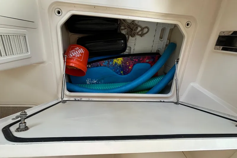 Slide: The Image of Storage compartment on a 2013 Grady-White Freedom 335 boat with various items inside. - 41