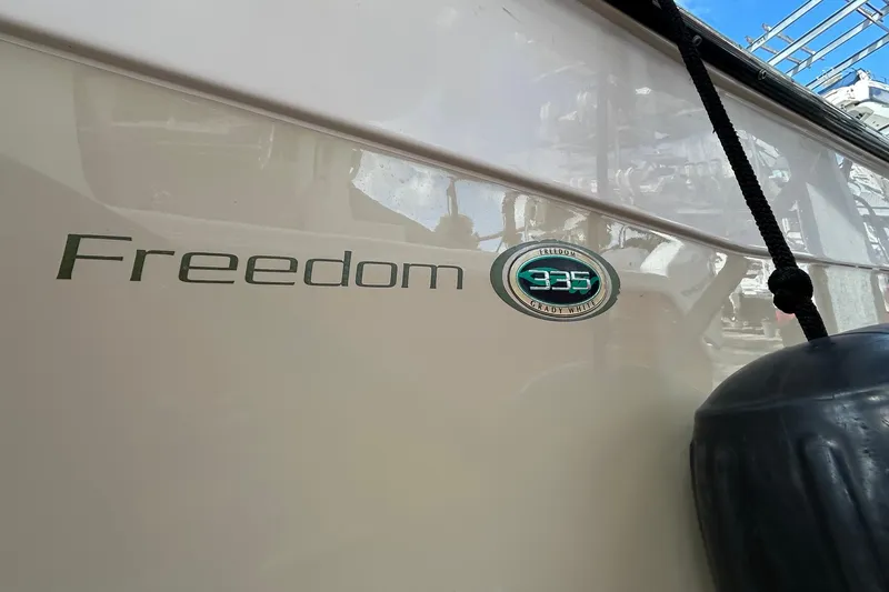 Slide: The Image of 2013 Grady-White Freedom 335 boat side view with logo and fender. - 5