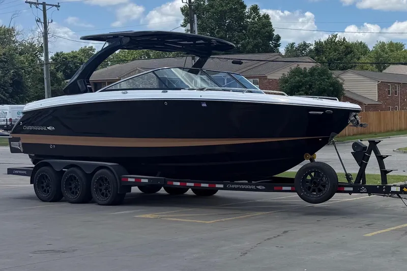 The Image of 2023 Chaparral 30 Surf boat on trailer, parked outdoors under a blue sky. - 1