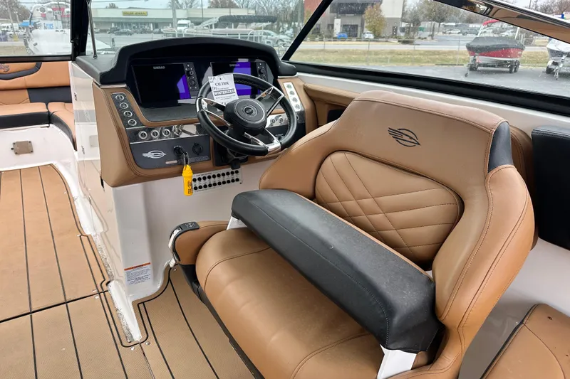 Slide: The Image of 2023 Chaparral 30 Surf boat interior with tan leather seating and modern dashboard. - 8