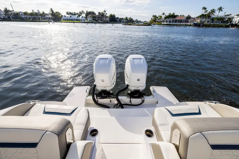 Slide: The Image of 2022 Tiara 34 LX boat with dual engines on a sunny waterfront. - 16