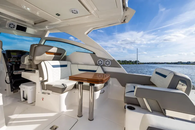 Slide: The Image of Luxurious interior of 2022 Tiara 34 LX yacht with seating and table, overlooking water. - 17