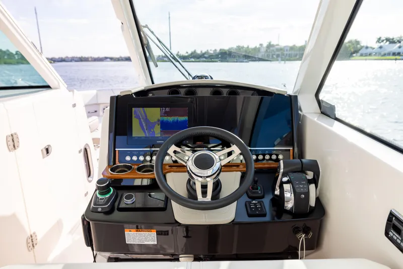 Slide: The Image of Helm of 2022 Tiara 34 LX boat with modern navigation controls and steering wheel. - 20