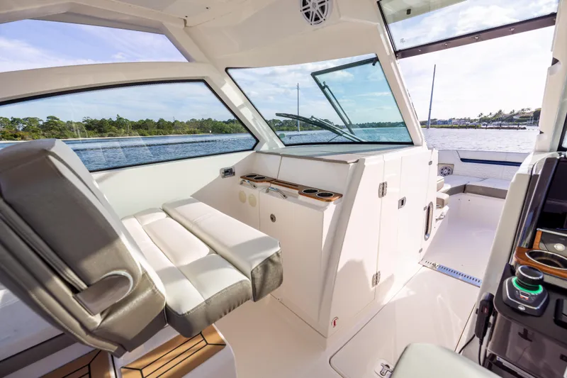 Slide: The Image of Interior of 2022 Tiara 34 LX boat with modern seating and panoramic windows. - 22