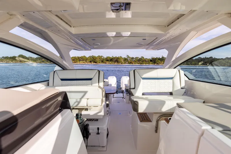 Slide: The Image of Interior view of 2022 Tiara 34 LX yacht with luxurious seating and scenic water backdrop. - 24