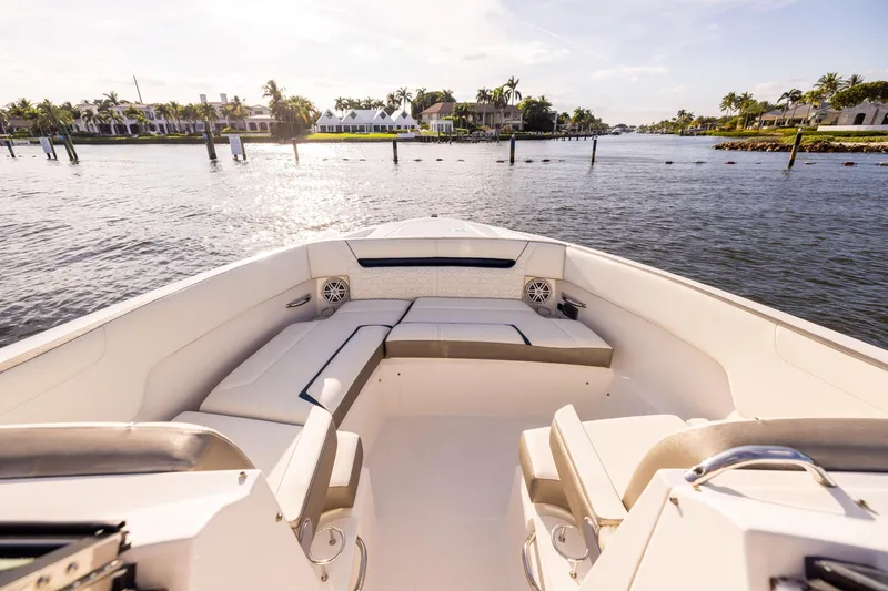 Slide: The Image of 2022 Tiara 34 LX boat interior with luxurious seating, cruising on a sunny waterfront. - 28