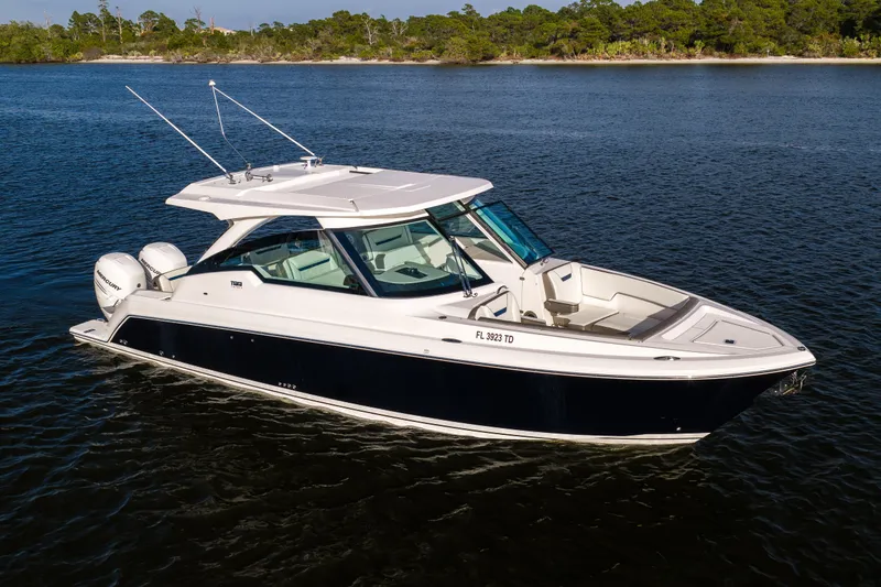 Slide: The Image of 2022 Tiara 34 LX boat on calm water, featuring sleek design and dual outboard engines. - 37