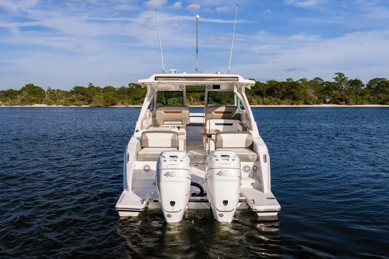Slide: The Image of 2022 Tiara 34 LX boat on water with twin engines, scenic shoreline background. - 40