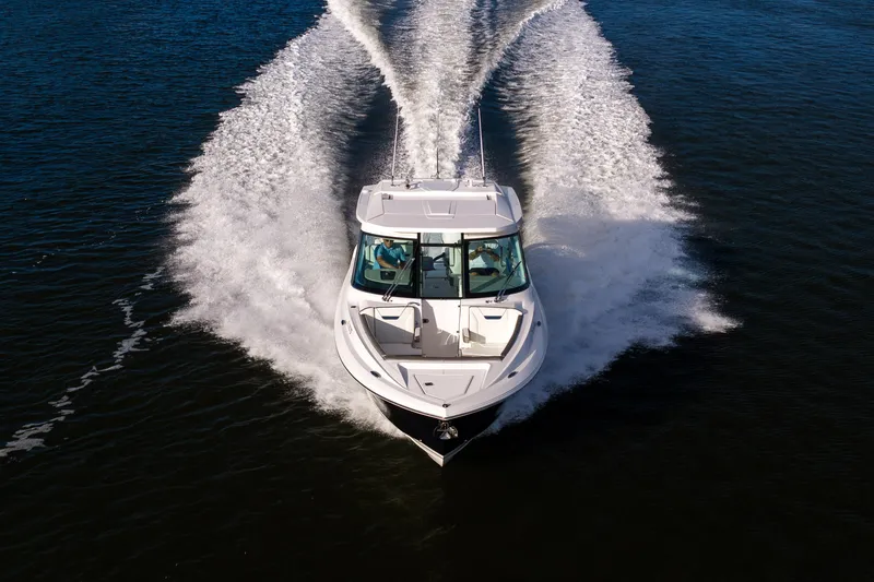 Slide: The Image of 2022 Tiara 34 LX boat cruising on open water, creating a dynamic wake. - 45