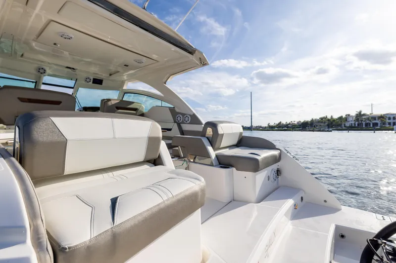 Slide: The Image of 2022 Tiara 34 LX boat interior with luxurious seating on a sunny day. - 6
