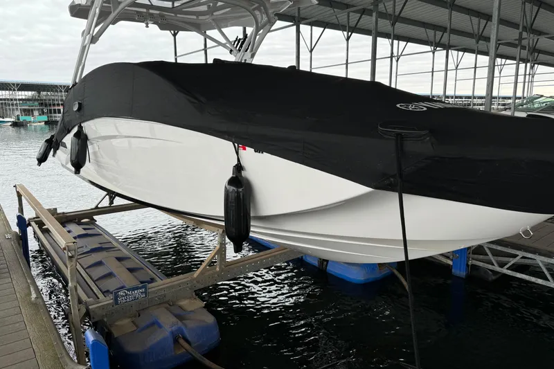 Slide: The Image of 2024 Yamaha Boats 275SD covered and docked at a marina. - 19