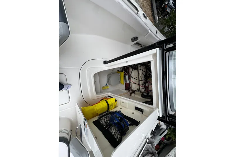 Slide: The Image of 2021 Robalo R230 Center Console boat storage compartment with safety gear and equipment. - 13