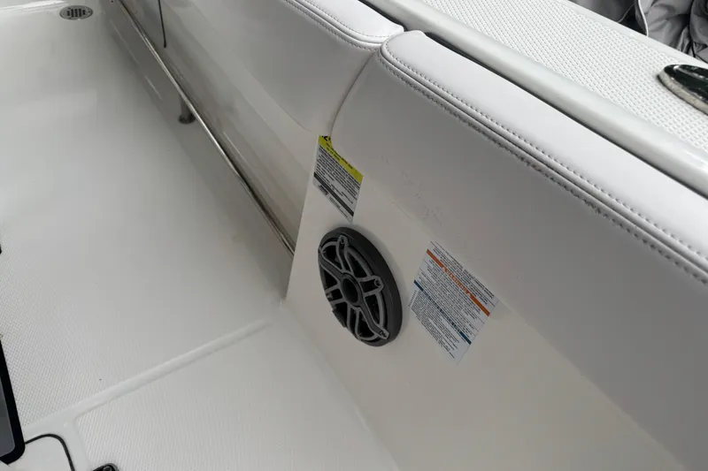 Slide: The Image of 2021 Robalo R230 Center Console boat interior with speaker and safety labels. - 15