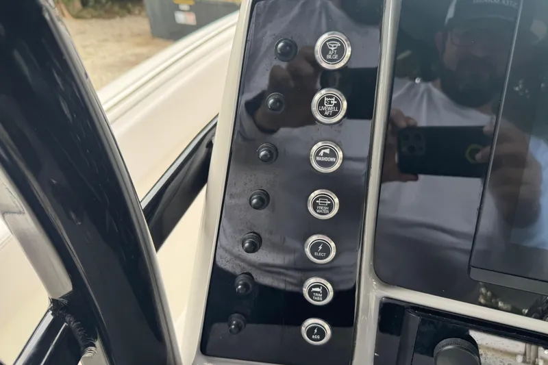 Slide: The Image of 2021 Robalo R230 Center Console dashboard with control buttons and reflection. - 23