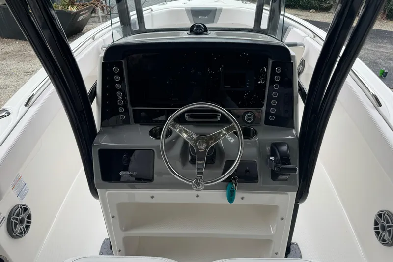 Slide: The Image of 2021 Robalo R230 Center Console boat dashboard with steering wheel and controls. - 7