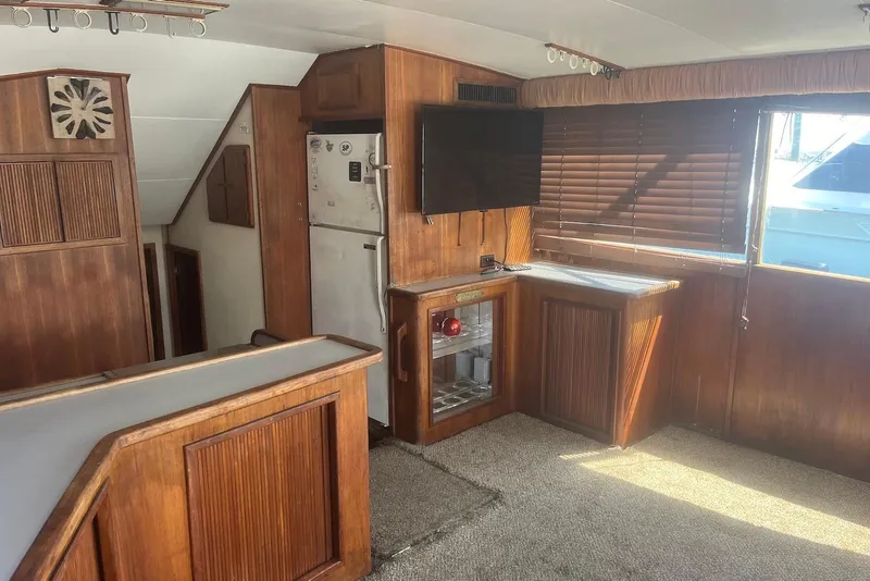 Slide: The Image of 1989 Topaz 44 Sportfisherman interior with wood paneling, TV, and window blinds. - 13