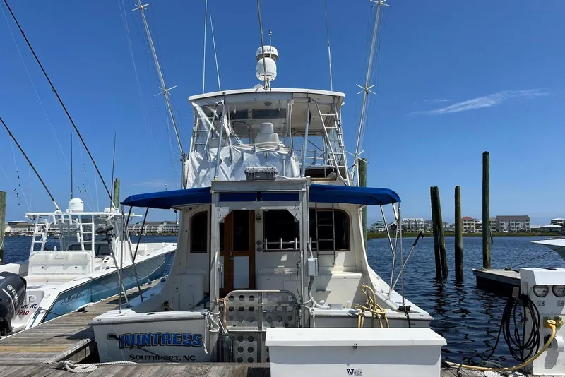 Slide: The Image of 1989 Topaz 44 Sportfisherman docked, featuring "Huntress" name and Southport, NC location. - 3